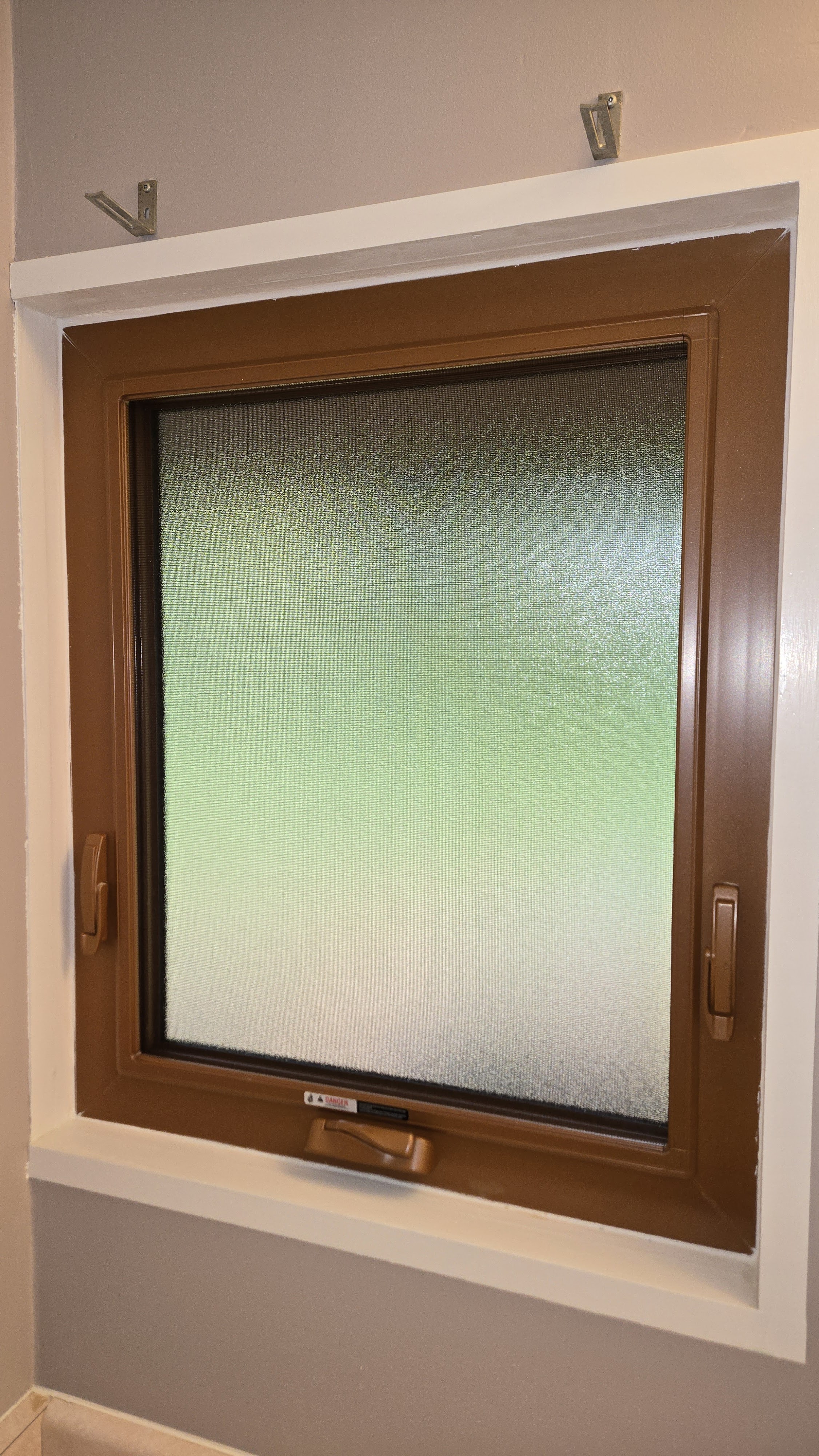 Energy-efficient awning window with frosted glass upgrade in the bathroom of a Richmond home with custom colour finish