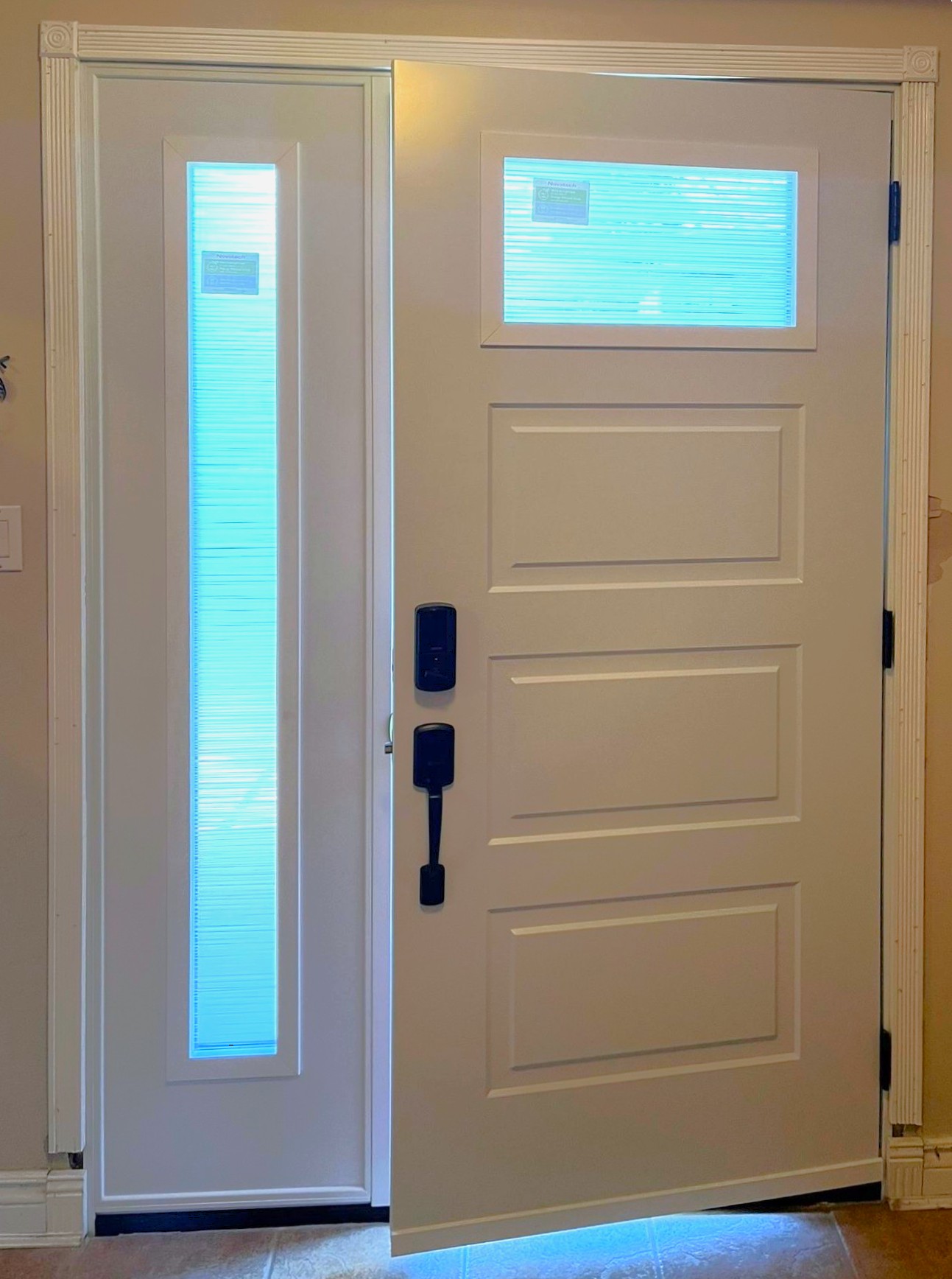 Modern house entry from interior featuring white steel door and privacy glazing in Coquitlam, BC