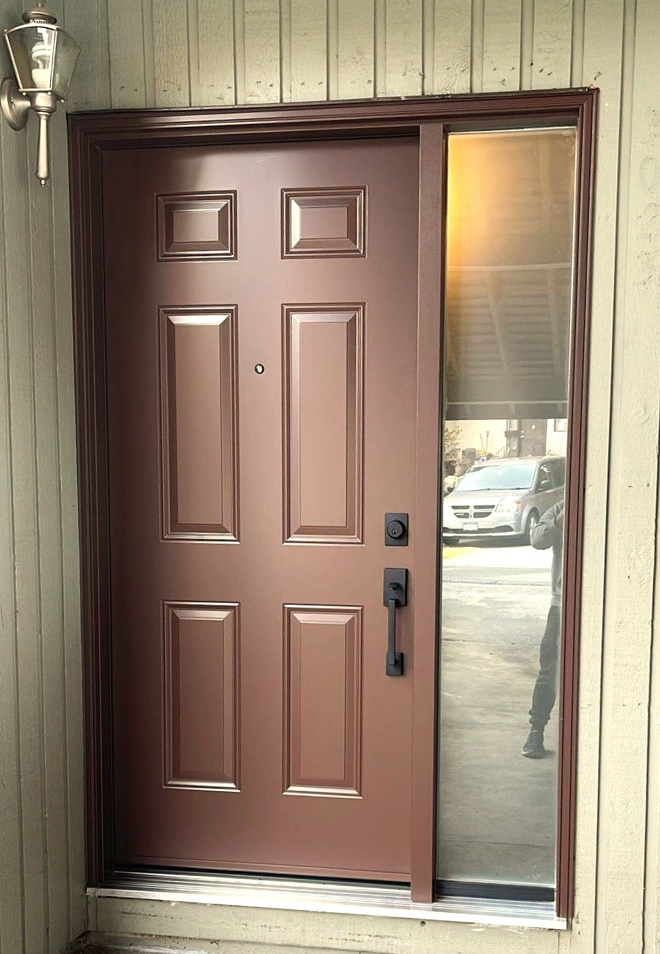Custom brown steel entry door with sidelight installed in a Vancouver home