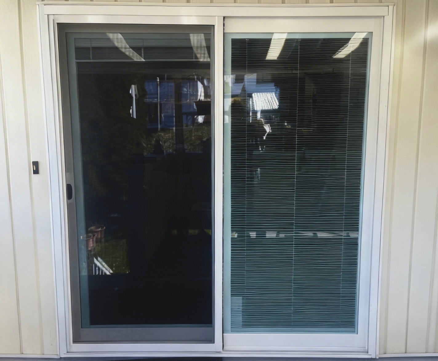 White vinyl patio door with internal blinds installed for an easy access to a backyard in Delta home