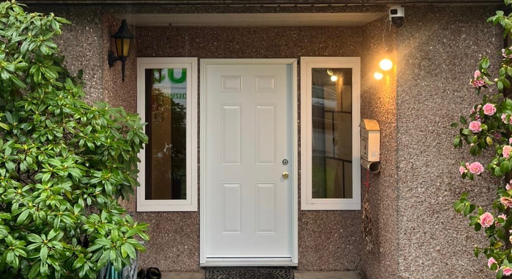 Modern white entry door installed in a residential apartment building with 2 picture windows in Richmond